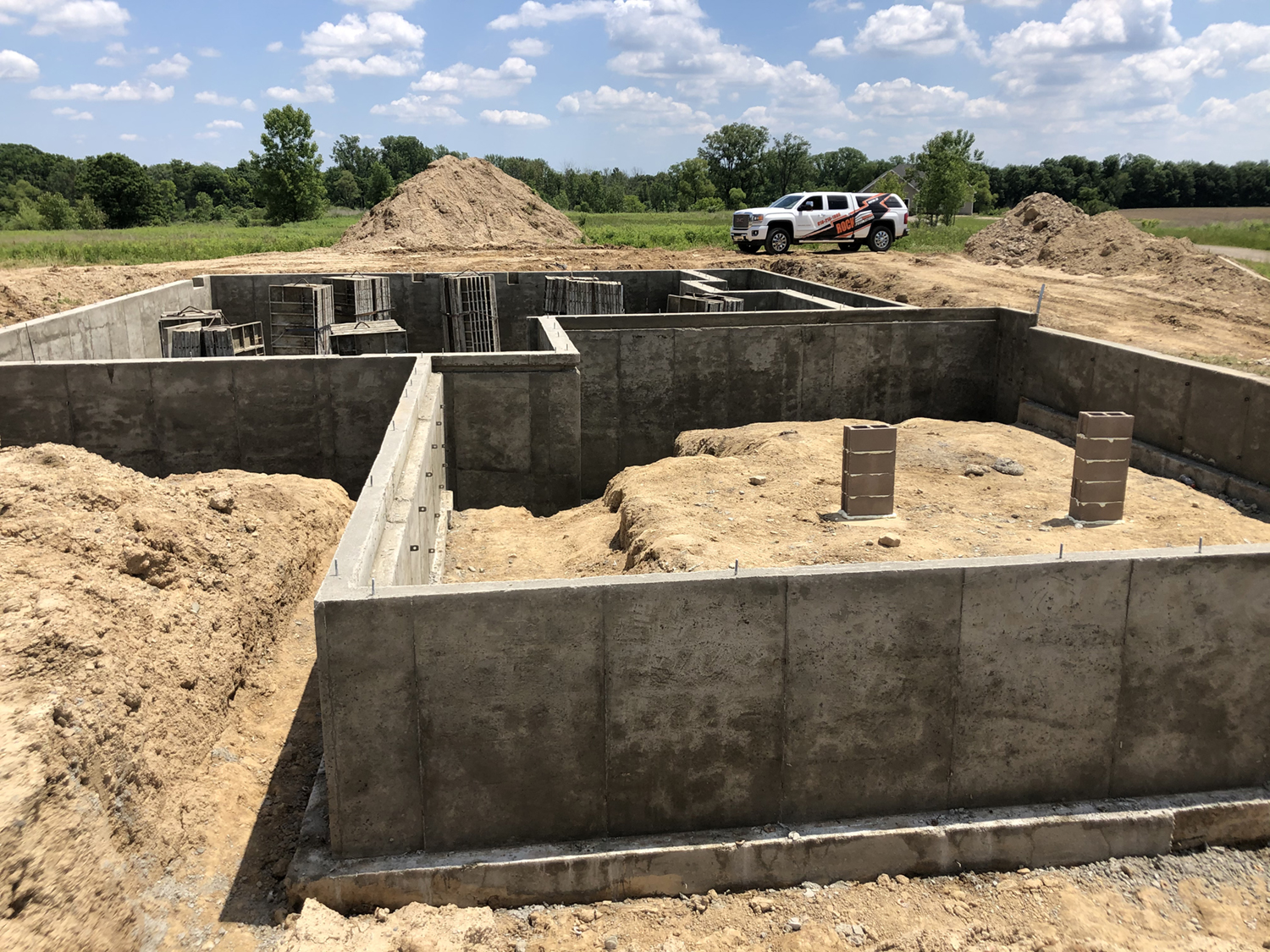 A homes foundation being built with a Rock Foundations truck in the background